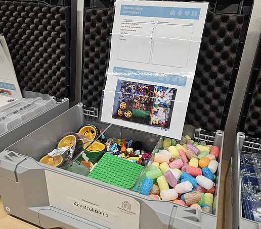 Eine Versuchsanlage mit buntem Spielmais in einem speziellen Konstruktionskoffer im Anhänger.