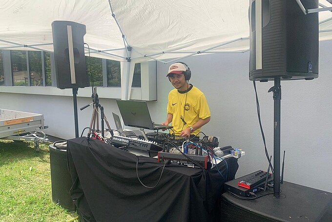 Ein DJ legt Musik an seinem DJ-Pult auf.