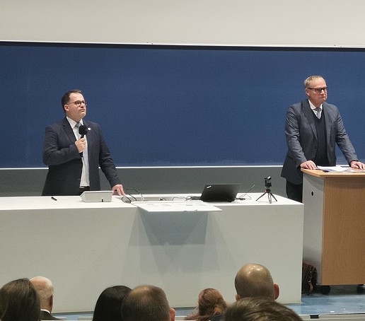 Rektor und Generalstaatsanwalt im Hörsaal auf dem Podium.
