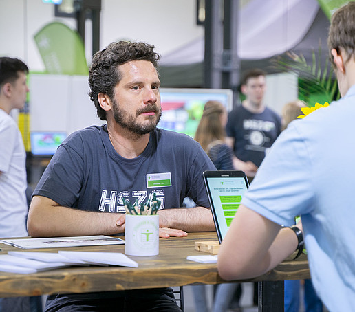 Ein HSZG-Mitarbeiter berät einen Gast.