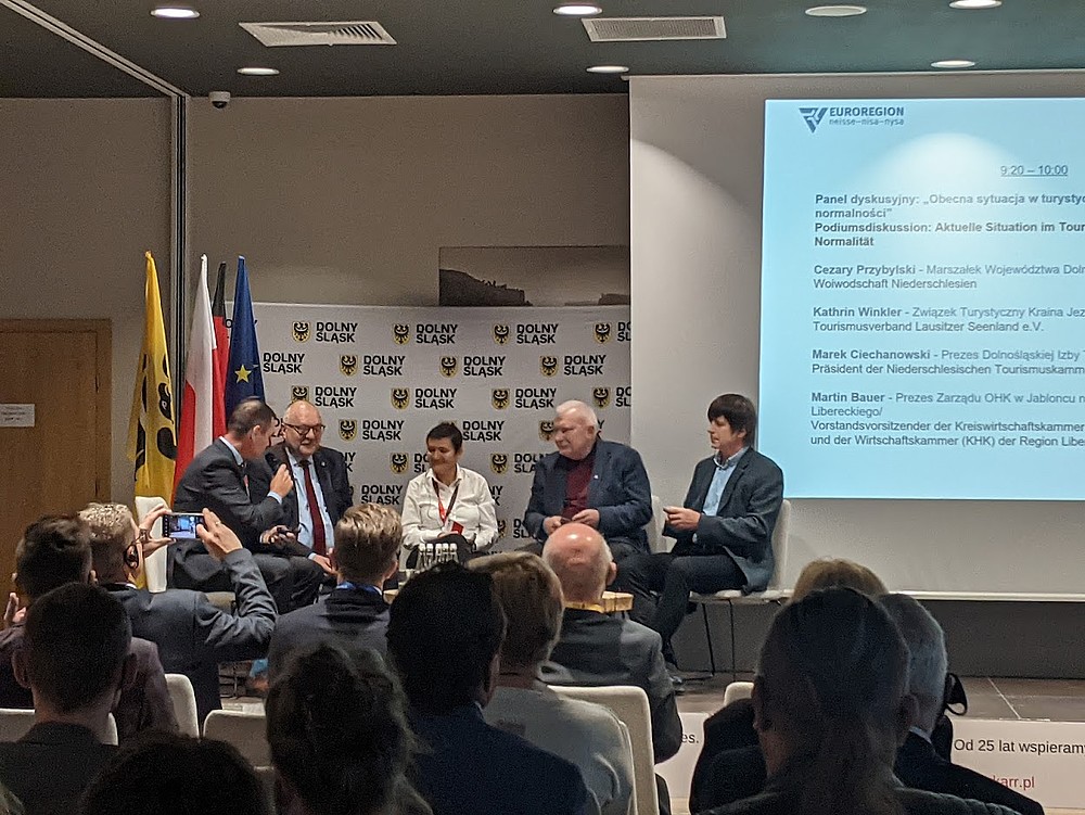 Tagungssaal mit 5 Personen im Podium