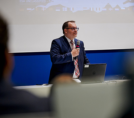 Rektor Kratzsch hält im Hörsaal ein Mikro in der Hand und hält eine Rede.