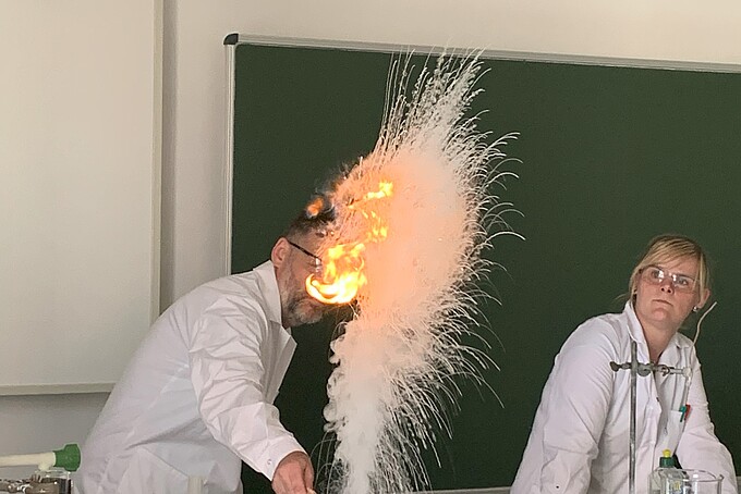 Bei einem Experiment im Seminarraum steigt Dampf und eine kleine Feuerkugel auf.