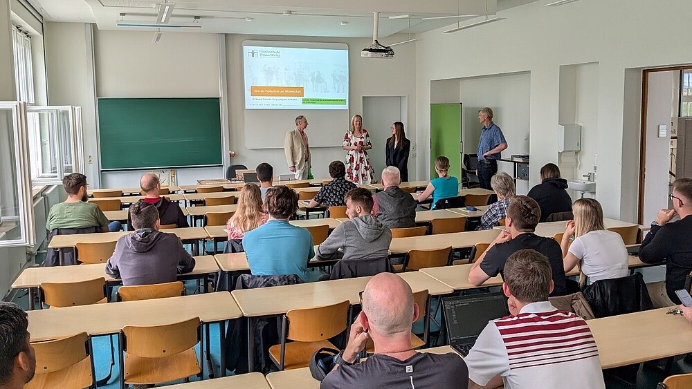 Die Prorektorin steht im Seminarraum vor besetzten Stuhlreihen und begrüßt das Publikum.