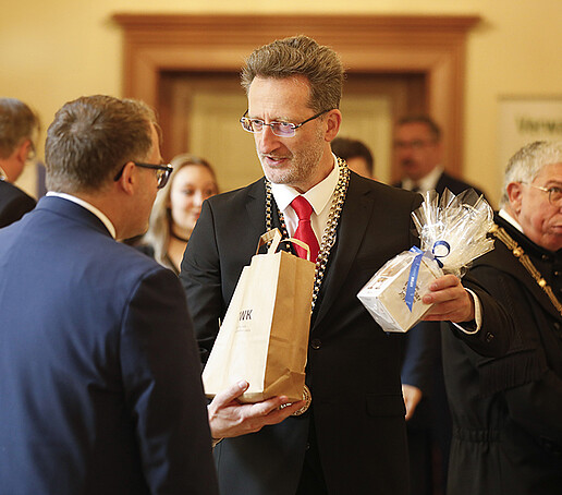 Der Rektor bekommt ein Geschenk zur Investitur von einem Gast überreicht.