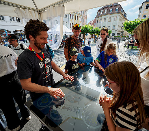 Ein HSZG-Mitarbeiter erklärt Standbesuchenden den Wischtisch.