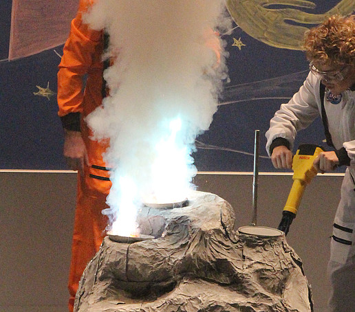 Ein Mitarbeiter im Raumanzug bohrt an einem Stein.
