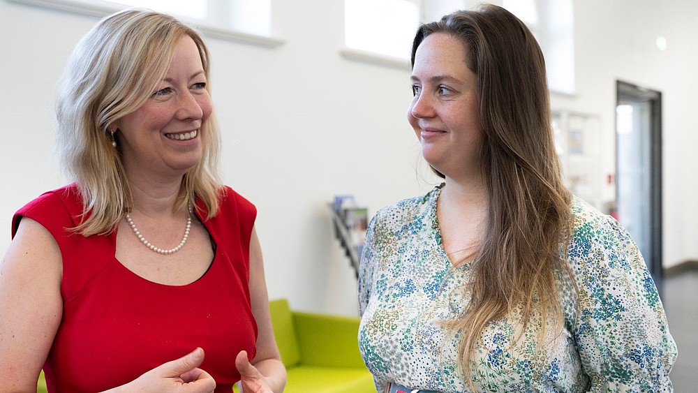 Prof. Keil und Frau Terlunen im Gespräch auf dem Gang in einem HSZG-Gebäude.