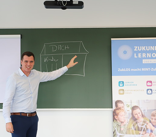 Ein Präsentator erklärt das Tafelbild.