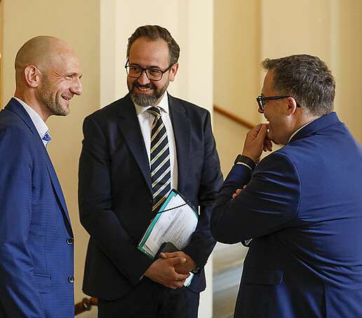 Landrat, Wissenschaftsminister und Rektor unterhalten sich im Treppenaufgang des Zittauer Rathauses.