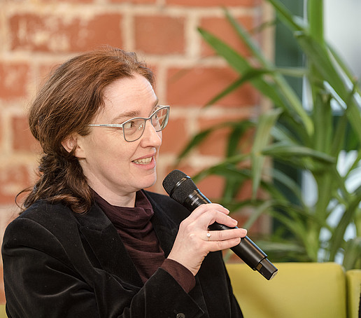 Lucie Koutková mit Mikro auf dem Talk-Sofa