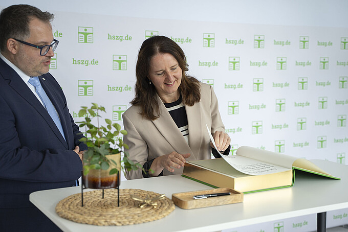 Prof. Dr. Heike Graßmann trägt sich im Beisein von Rektor Prof. Dr.-Ing. Alexander Kratzsch in das Goldene Buch der HSZG ein.