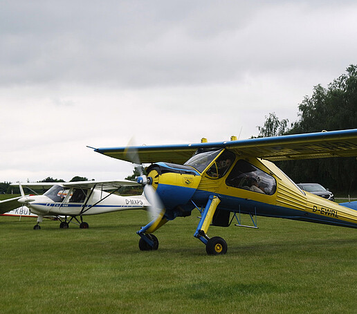 ein gelb-blaues Ultraleichtflugzeug auf dem Görlitzer Flugplatz.