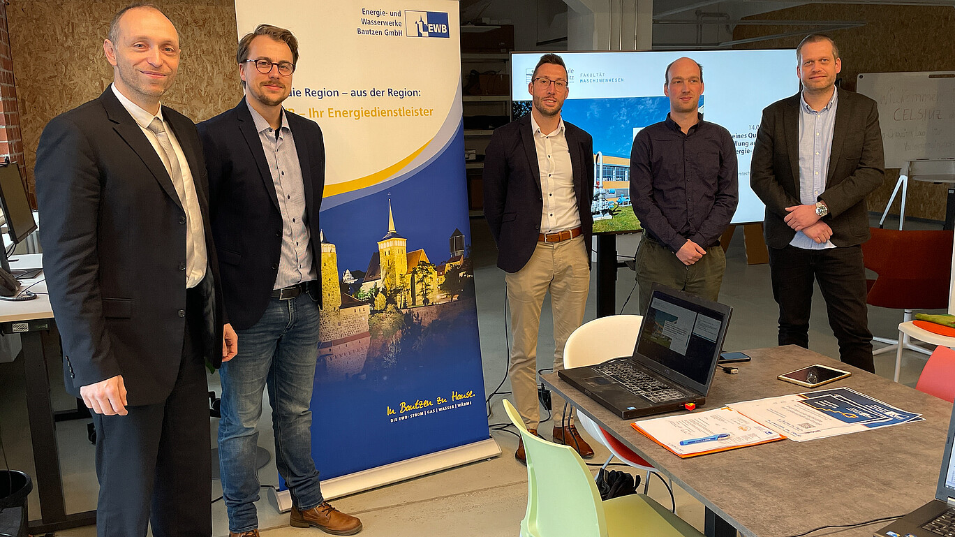 Vertreter der EWB und HSZG stehen vor einem Roll-up.