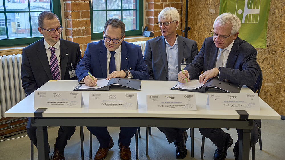 Vier Personen unterschreiben eine Erklärung