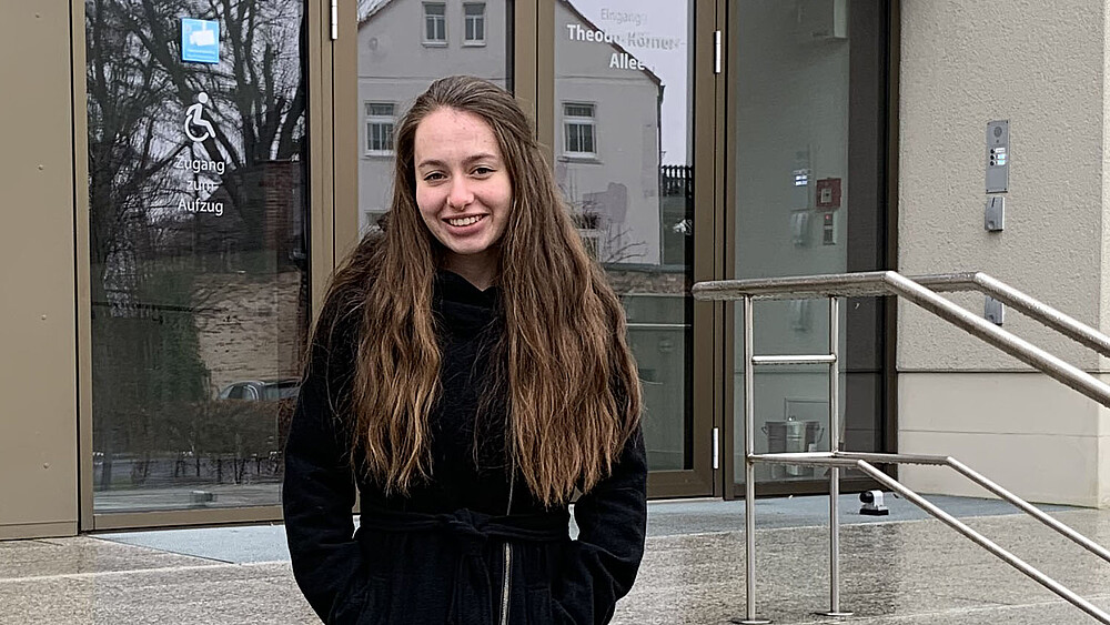 Maren Molch steht vor dem Haupteingang von Haus Z eins.