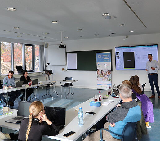 Workshopteilnehmende hören in einem Seminarraum einem Vortrag zu.