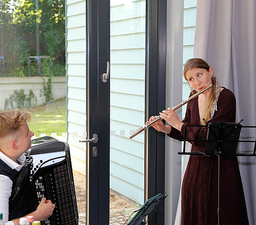 Eine Flötistin und ein Akkordeonspieler spielen in der Aula in Görlitz.