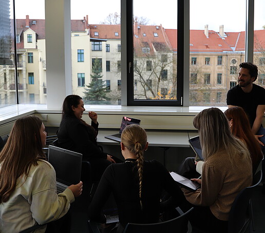 Eine Gruppe Workshopteilnehmende im Gespräch im Seminarraum.