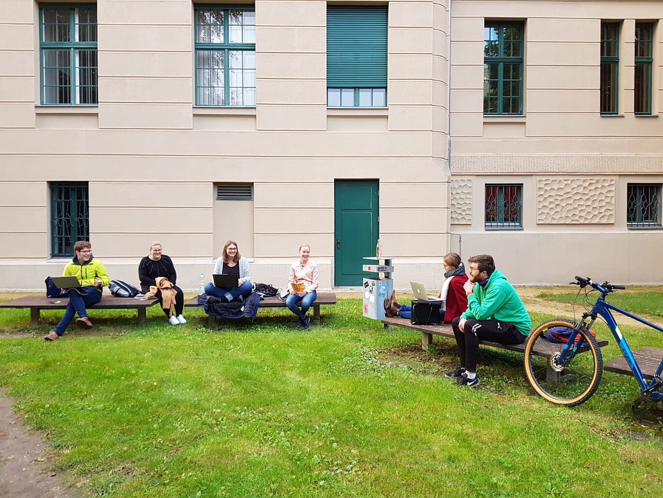 Studentengruppe, sitzend auf Bänken