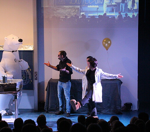 Der Eisbär und die Moderatoren auf der Bühne.