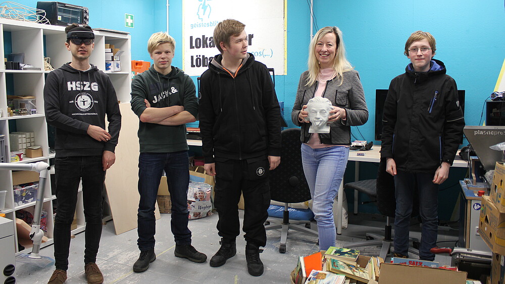 Eine Gruppe von Schülern steht mit der lächelnden Prorektorin im Werkraum.