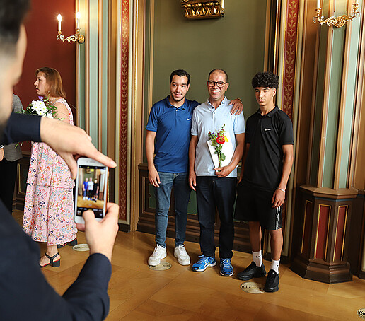 Absolventen und ihr Angehöriger machen ein Erinnerungsfoto.