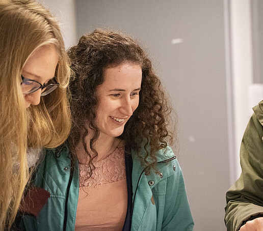 Zwei junge Frauen informieren sich an einem Stand.