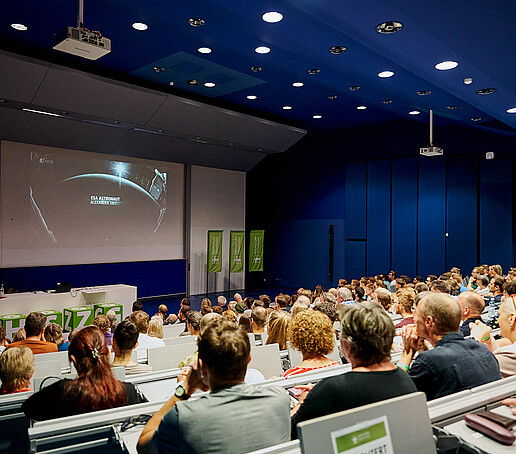 Vollbesetzte Sitzreihen im Hörsaal