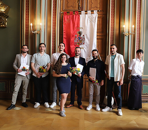 Kursteilnehmende stehen nebeneinander und halten ihre Urkunden in den Händen und posieren als Gruppe.