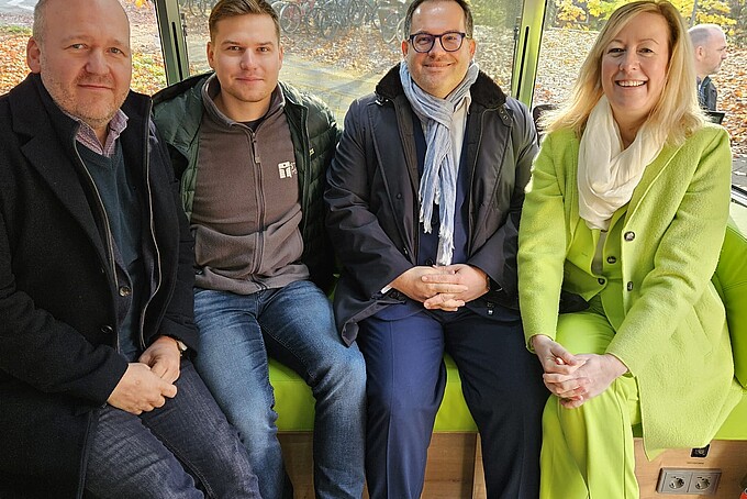 Vier Gäste sitzen im AirStream-Anhänger.