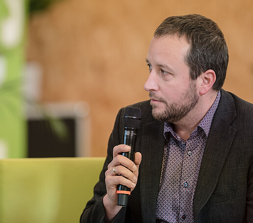Vertreter vom Studentenwerk Dresden mit Mikro auf dem Talk-Sofa