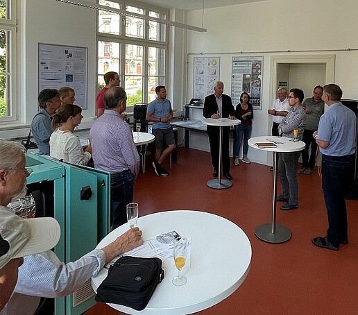 Menschen stehen im Labor und feiern die Eröffnung.