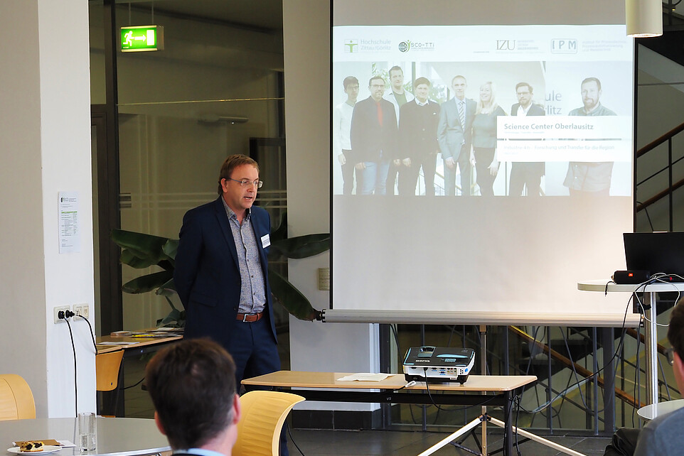 Prof. Kroschel hält vor Publikum einen Vortrag.