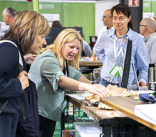 Eine HSZG-Mitarbeiterin erklärt einer Besucherin ein Exponat.
