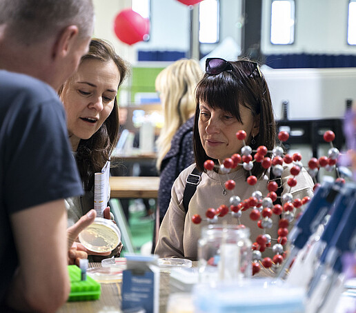 Besucherinnen am naturwissenschaftlichen Versuchsstand.