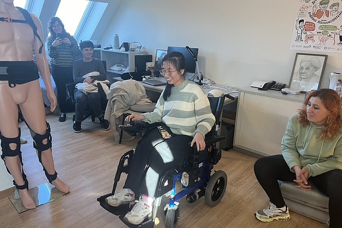 Eine Schülerin testen den elektrischen Rollstuhl im Labor