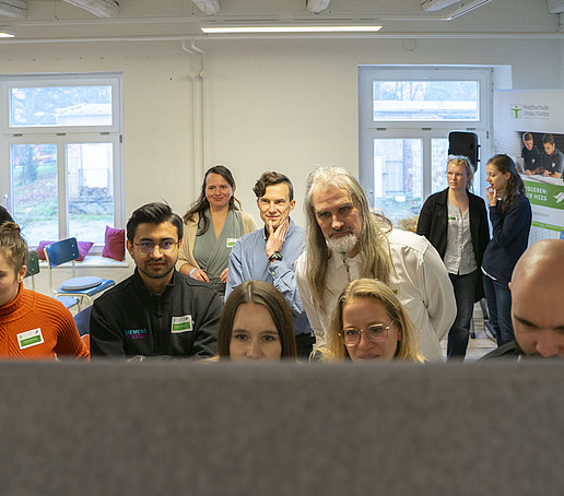 Eine Gruppe schaut auf ein Flipchart.