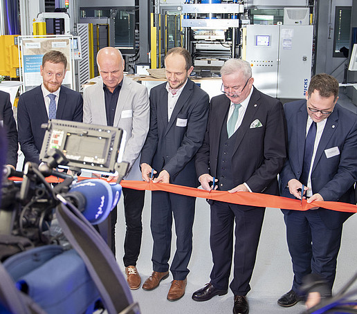 Die offiziellen Gäste schneiden das Eröffnungsband durch.