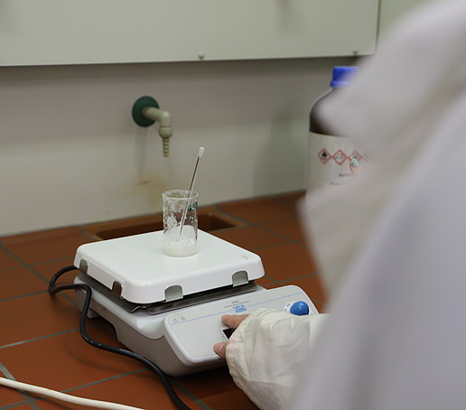 Ein Glasschälchen steht auf einer Messplatte unter dem Dunstabzug.