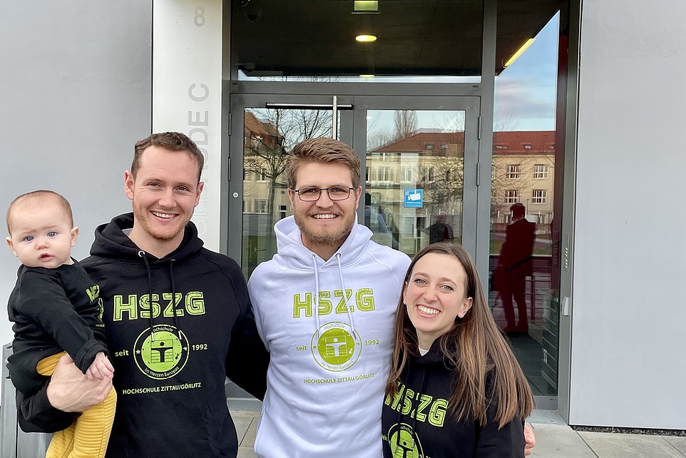 Südafrikaner mit Baby und Frau vor Gebäudeeingang