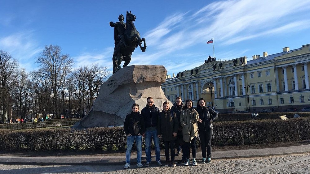 Studentinnen und Studenten bei einem Stadtrundgang vor einem Denkmal von Zar Peter dem Großen