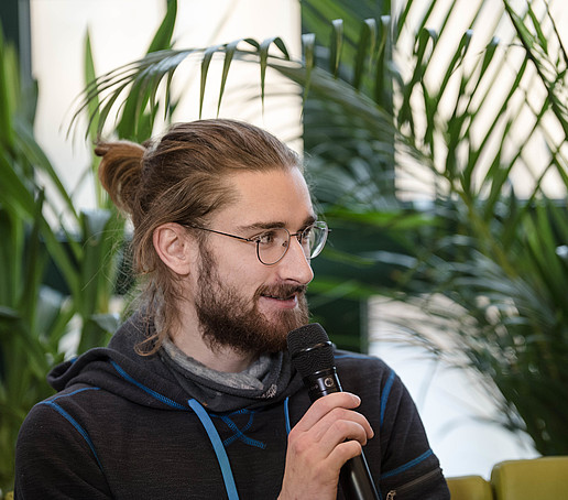 Student mit Mikro auf dem Talk-Sofa