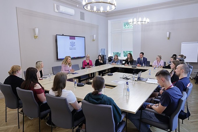 Gruppe von runnd 17 Menschen sitzt an Tischen in Carré-Form 