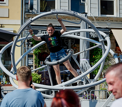 Eine Besucherin probiert ein Raumfahrtgerät auf dem Marktplatz aus.