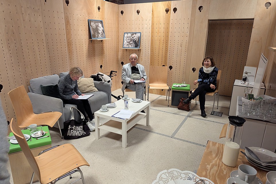 3 Personen sitzen im Raum und lesen