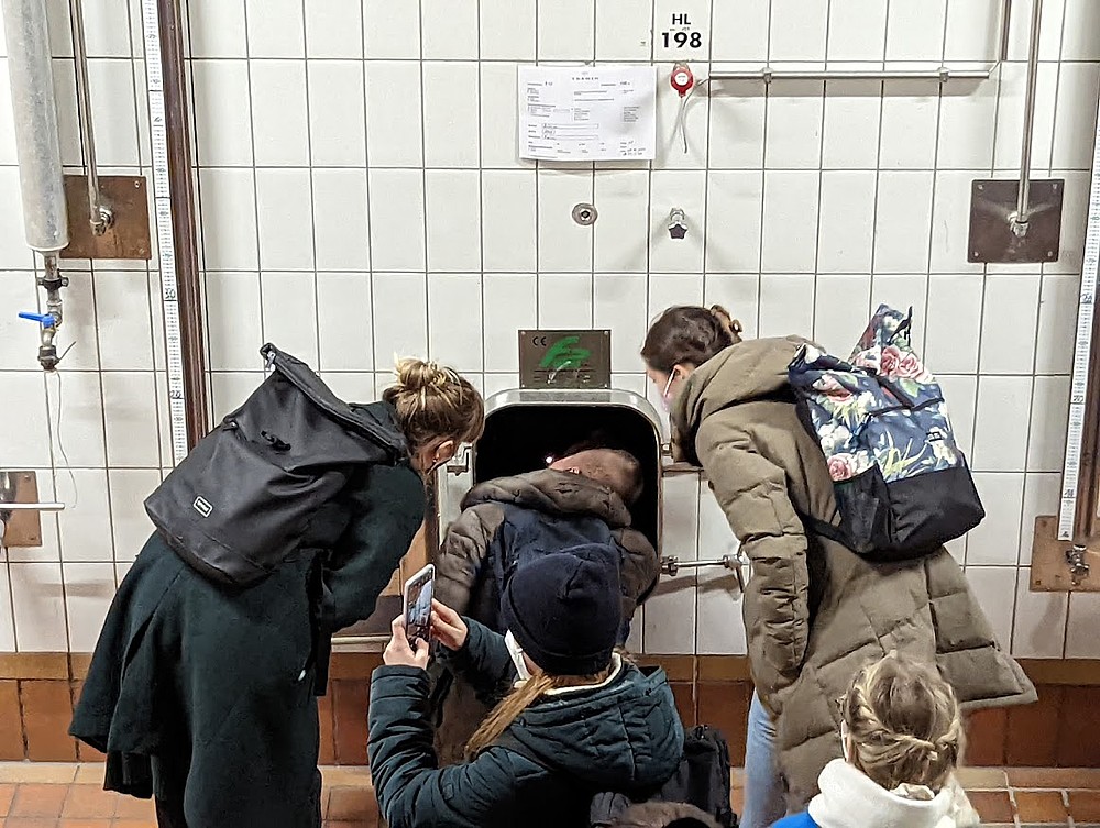 Vier Studierende vor einer gefliesten Wand.