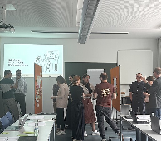 Teilnehmer stehen um Pinnwände und tauschen sich aus