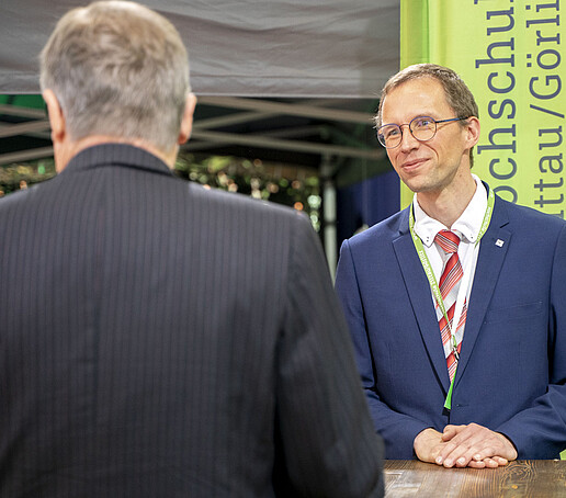 Prof. Kornhuber steht vor der HSZG-Fahne.