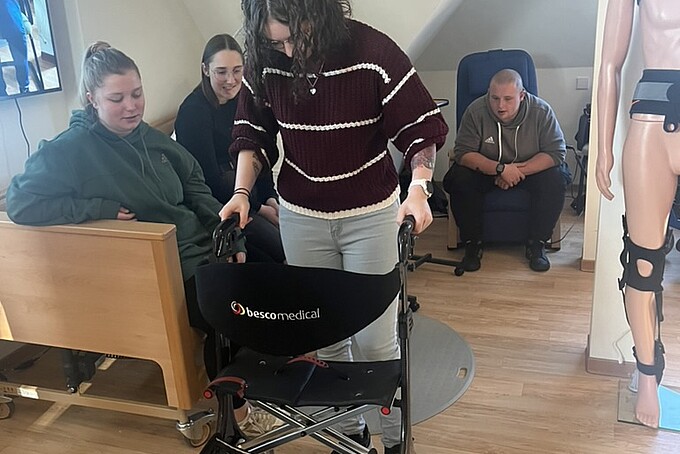 Eine Schülerin probiert den Leichtgewichtsrollator aus